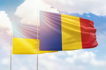 Sunny blue sky and flags of romania and ukraine