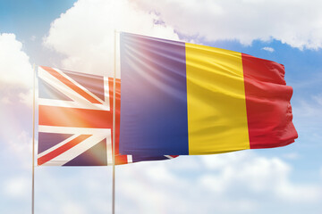Sunny blue sky and flags of romania and united kingdom