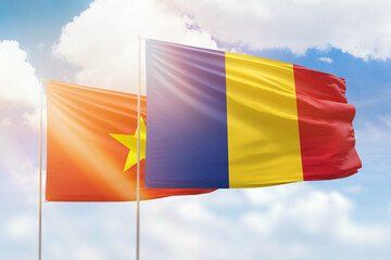 Sunny blue sky and flags of romania and vietnam