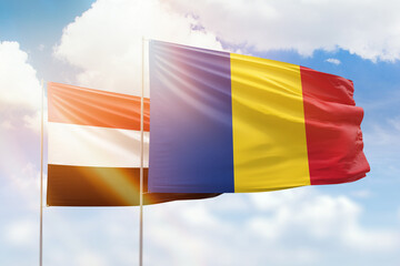 Sunny blue sky and flags of romania and yemen