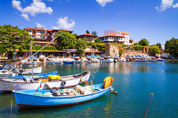 Fototapeta na wymiar Seaside cityscape - view of the pier with boats and embankment in the Old Town of Nessebar, on the Black Sea coast of Bulgaria