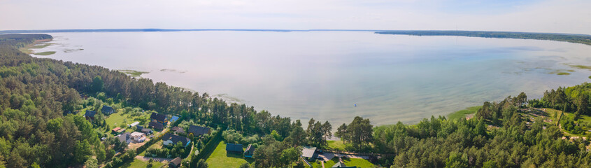 Aerial view of lake with sky reflection. Blue lake and green forest. Image for design. Space for text.