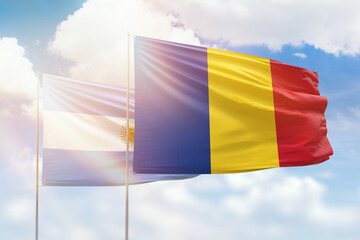 Sunny blue sky and flags of romania and argentina