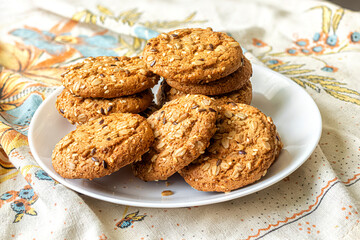 White plate with oatmeal cookies on a canvas towel