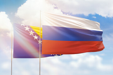Sunny blue sky and flags of russia and bosnia