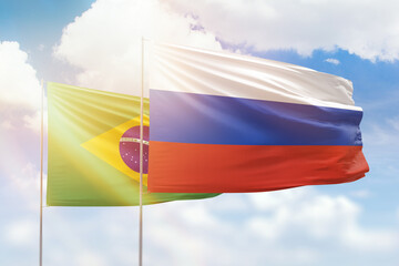 Sunny blue sky and flags of russia and brazil