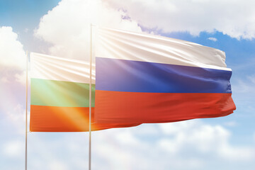 Sunny blue sky and flags of russia and bulgaria