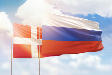 Sunny blue sky and flags of russia and denmark