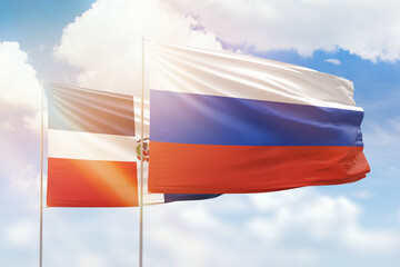 Sunny blue sky and flags of russia and dominican republic