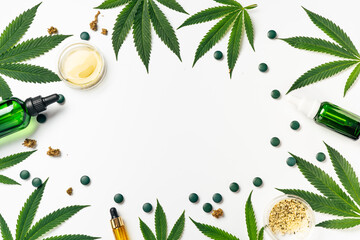 Green hemp leaves, cosmetics and tablets on white with copy space. Natural cosmetics, superfood,...