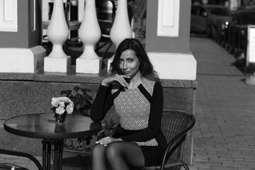 Obraz premium Beautiful woman on the summer terrace of a cafe in black and white