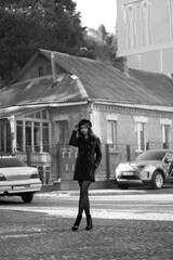 Beautiful slender woman in a cap in the street in black and white