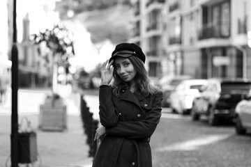 Beautiful slender woman in a cap in the street in black and white