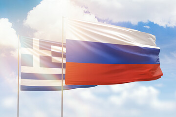 Sunny blue sky and flags of russia and greece