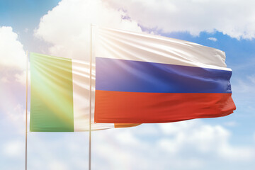 Sunny blue sky and flags of russia and ireland