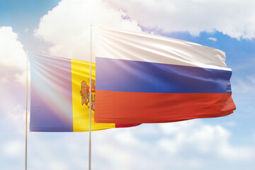 Sunny blue sky and flags of russia and moldova