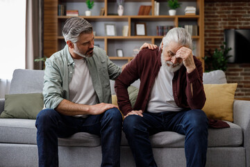 An elderly father complains about life to an adult son, which help him to calm dawn. Two generations family has conversation, sharing news, spending time together. Understanding, care and support. - obrazy, fototapety, plakaty