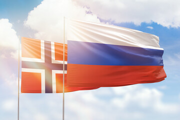 Sunny blue sky and flags of russia and norway