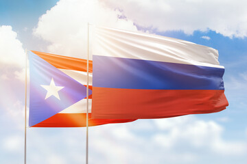 Sunny blue sky and flags of russia and puerto rico