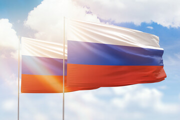 Sunny blue sky and flags of russia and russia