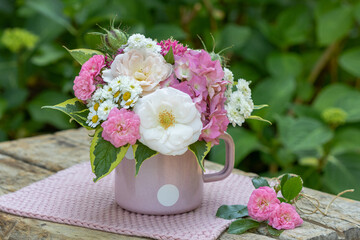 romantischer Blumenstrauß mit Rosen, Hortensien und Bertrams Garbe in Emaille-Tasse