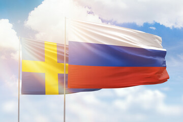 Sunny blue sky and flags of russia and sweden