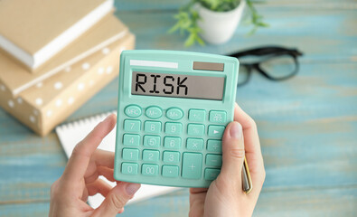 Elevated View Of Risk Word On Calculator in hands