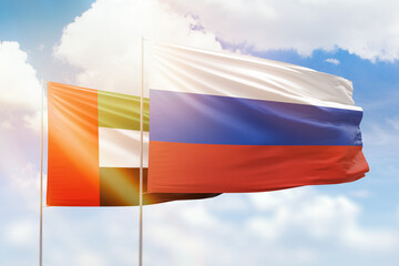 Sunny blue sky and flags of russia and uae