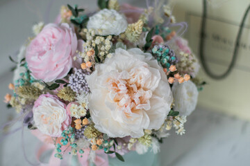 Beautiful spring flowers in box of tender peonies, roses and Gypsophila flowers. Preserved flowers for womens.