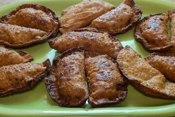 A close-up of freshly made homemade tuna dumplings on a green plate. Traditional recipes.