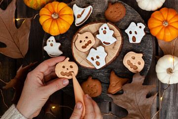 Homemade halloween holiday treats for kids. Gingerbread cookies on wooden board, decorated with...