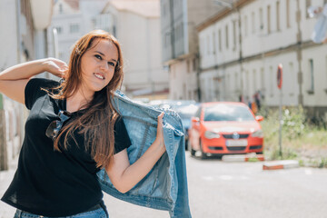 Fototapeta premium girl in the street putting on her jacket