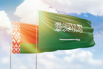 Sunny blue sky and flags of saudi arabia and belarus