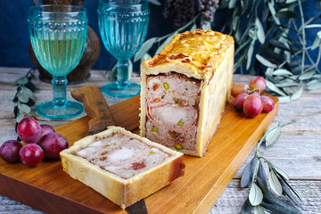 Traditional French Pate en croute with rabbit meat and pork filet serviert with grapes as close-up...