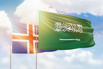 Sunny blue sky and flags of saudi arabia and iceland