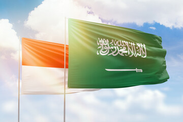 Sunny blue sky and flags of saudi arabia and indonesia