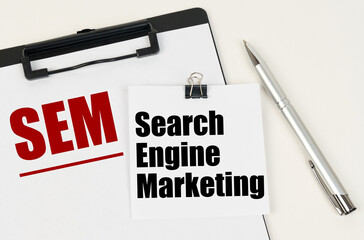 On the tablet, a sheet of paper and stickers with the inscription - SEM, Search Engine Marketing