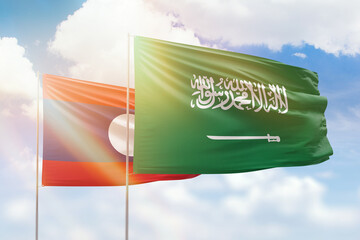 Sunny blue sky and flags of saudi arabia and laos