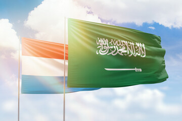 Sunny blue sky and flags of saudi arabia and luxembourg