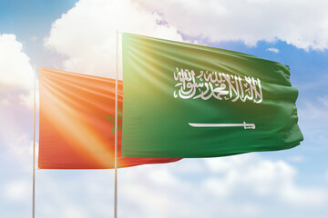 Sunny blue sky and flags of saudi arabia and morocco