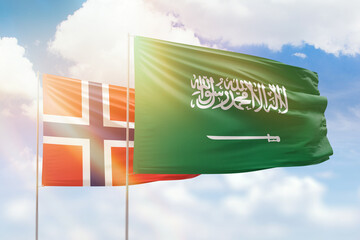 Obraz premium Sunny blue sky and flags of saudi arabia and norway