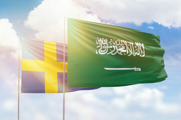 Sunny blue sky and flags of saudi arabia and sweden