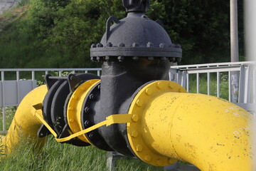 Pipeline with valve. Yellow pipe with a blue tap, oil and gas industry, gas price increase, gas...