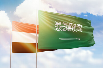 Sunny blue sky and flags of saudi arabia and yemen