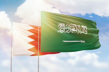 Sunny blue sky and flags of saudi arabia and bahrain