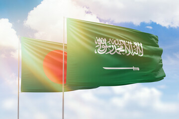 Sunny blue sky and flags of saudi arabia and bangladesh