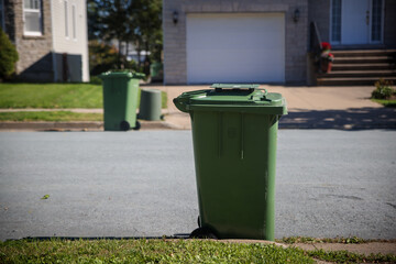 Recycling green garbage carts set outside of the homes on the curb for residential garbage and...