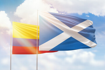 Sunny blue sky and flags of scotland and colombia