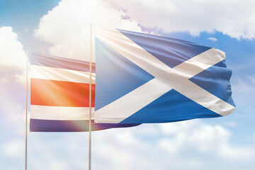 Sunny blue sky and flags of scotland and costa rica