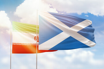 Sunny blue sky and flags of scotland and iran